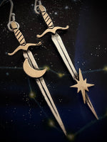 Decorative sword and star earrings on a dark background