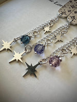 Close-up of star-shaped charms and beads on a book's title page. 