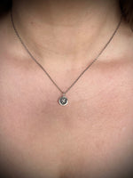 Necklace with a dragon pendant worn on a person's neck. 