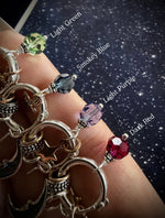 Charm hoop earrings labeled from top to bottom: Light Green, Smokey Blue, Light Purple, Dark Red.