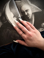 Hand with painted nails touching a classical painting