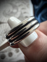 Silver ring on a finger with a blurred background